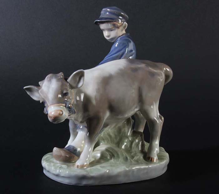 Статуэтка Мальчик с теленком. Фарфор, роспись. Дания, Royal Copenhagen, около 1980 годаАОКАРГК Статуэтка Мальчик с теленком. Фарфор, роспись. Дания, Royal Copenhagen, около 1980 годаАОКАРГКРоскошная скульптура марки Royal Copenhagen! Превосходная идея для подарка ценителю! Скульптура Кристиана Томсена, известного художника Датской Королевской фарфоровой мануфактуры, выполнена в виде мальчика, который тянет за собой упрямого бычка. Тот недовольно крутит головой и мальчику приходится прилагать усилия, чтобы теленок следовал за ним. Замечательный пример безупречной фарфоровой пластики мастеров Royal Copenhagen. Великолепно передан характер персонажей, проработаны детали. Неповторимое украшение Вашей коллекции фарфора! Статуэтка Мальчик с теленком. Фарфор, роспись. Дания, Royal Copenhagen, около 1980 года. Размер 16,8 х 10 х 17,1 см. Сохранность коллекционная. На основании зеленое клеймо Royal Copenhagen, синее клеймо в виде трех волнистых линий, номер 772. Автор - Кристиан Томсен (Christian Thomsen).