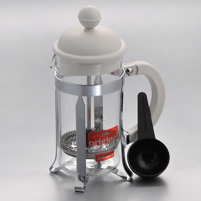 Кофейник Bodum Caffettiera с прессом, с ложечкой, цвет: белый, 0,35 л1913-913 Кофейник Bodum Caffettiera с прессом, с ложечкой, цвет: белый, 0,35 л1913-913Кофейник Bodum Caffettiera представляет собой колбу из термостойкого стекла в оправе из полированной нержавеющей стали. Кофейник оснащен фильтром french press из нержавеющей стали, который позволяет легко и просто приготовить отличный напиток. Ручка и крышка кофейника выполнены из прочного пластика белого цвета. В комплекте небольшая мерная ложечка из черного пластика. Благодаря такому кофейнику приготовление вкуснейшего ароматного и крепкого кофе займет всего пару минут. Настоящим ценителям натурального кофе широко известны основные и наиболее часто применяемые способы его приготовления: эспрессо, по-турецки, гейзерный. Однако существует принципиально иной способ, известный как french press, благодаря которому приготовление ароматного напитка стало гораздо проще. Весь процесс приготовления кофе займет не более 7 минут. Характеристики: Материал: нержавеющая сталь, пластик, стекло. Цвет: белый. Объем: 0,35 л. Диаметр кофейника по верхнему...
