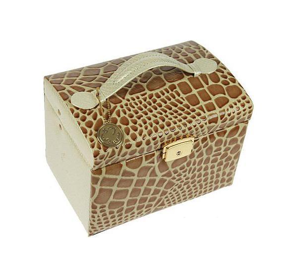 Шкатулка для ювелирных украшений CALVANI 18*13*13см 8339383393 Шкатулка для ювелирных украшений CALVANI 18*13*13см 8339383393Шкатулка Русские подарки CALVANI 83393 для хранения ювелирных украшений не оставит равнодушной ни одну любительницу изысканных вещей. На внутренней стороне крышки расположено небольшое удобное зеркальце. Данная модель закрывается на защелку-замок, которую можно закрыть ключиком, входящим в комплект, и имеет удобную ручку. Сочетание оригинального дизайна и функциональности сделает такую шкатулку практичным и стильным подарком и предметом гордости ее обладательницы. Материал: кож. зам., картон, текстиль, стекло; цвет: бежевый