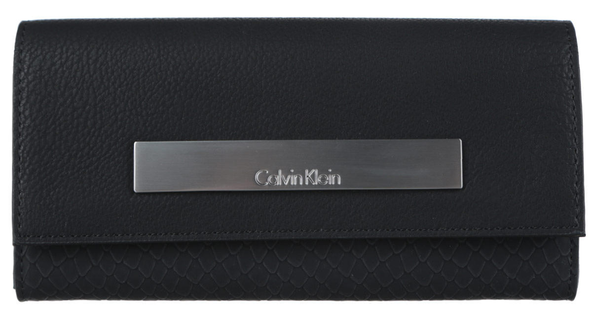 Кошелек женский Calvin Klein Jeans, цвет: черный. K60K601553_9100K60K601553_9100 Кошелек женский Calvin Klein Jeans, цвет: черный. K60K601553_9100K60K601553_9100Элегантный кошелек Calvin Klein выполнен из искусственной кожи (полиуретана) с декоративным фактурным тиснением под кожу рептилии и оформлен металлической пластиной с гравировкой в названия бренда. Изделие закрывается клапаном на кнопку. Внутри кошелька расположены два отделения для купюр, отделение для монет на молнии, потайной кармашек и двенадцать карманов для пластиковых карт. Изделие поставляется фирменной упаковке. Практичный аксессуар прекрасно дополнит ваш образ.