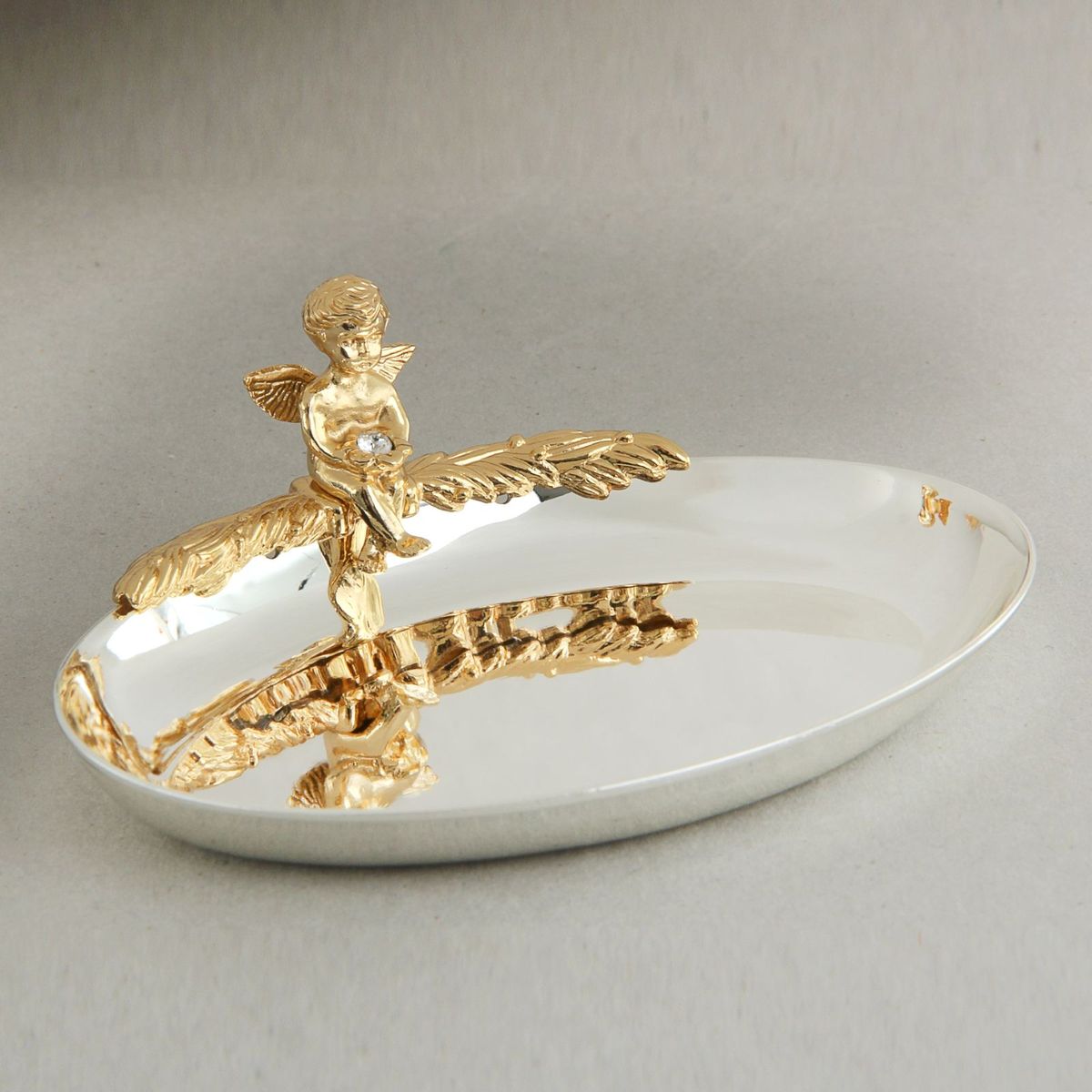 Swarovski Elements Блюдце для колец овал с ангелом 11,5х4х9 см882314 Swarovski Elements Блюдце для колец овал с ангелом 11,5х4х9 см882314Главный символ новой семьи – обручальные кольца - требуют особого обращения. К ним, согласно русским обычаям, не должен прикасаться никто кроме молодоженов и матери жениха, которая до бракосочетания должна хранить кольца в своем доме. Чтобы никто из посторонних, поднося кольца, не прикоснулся к ним, нужно блюдце или подушечка.