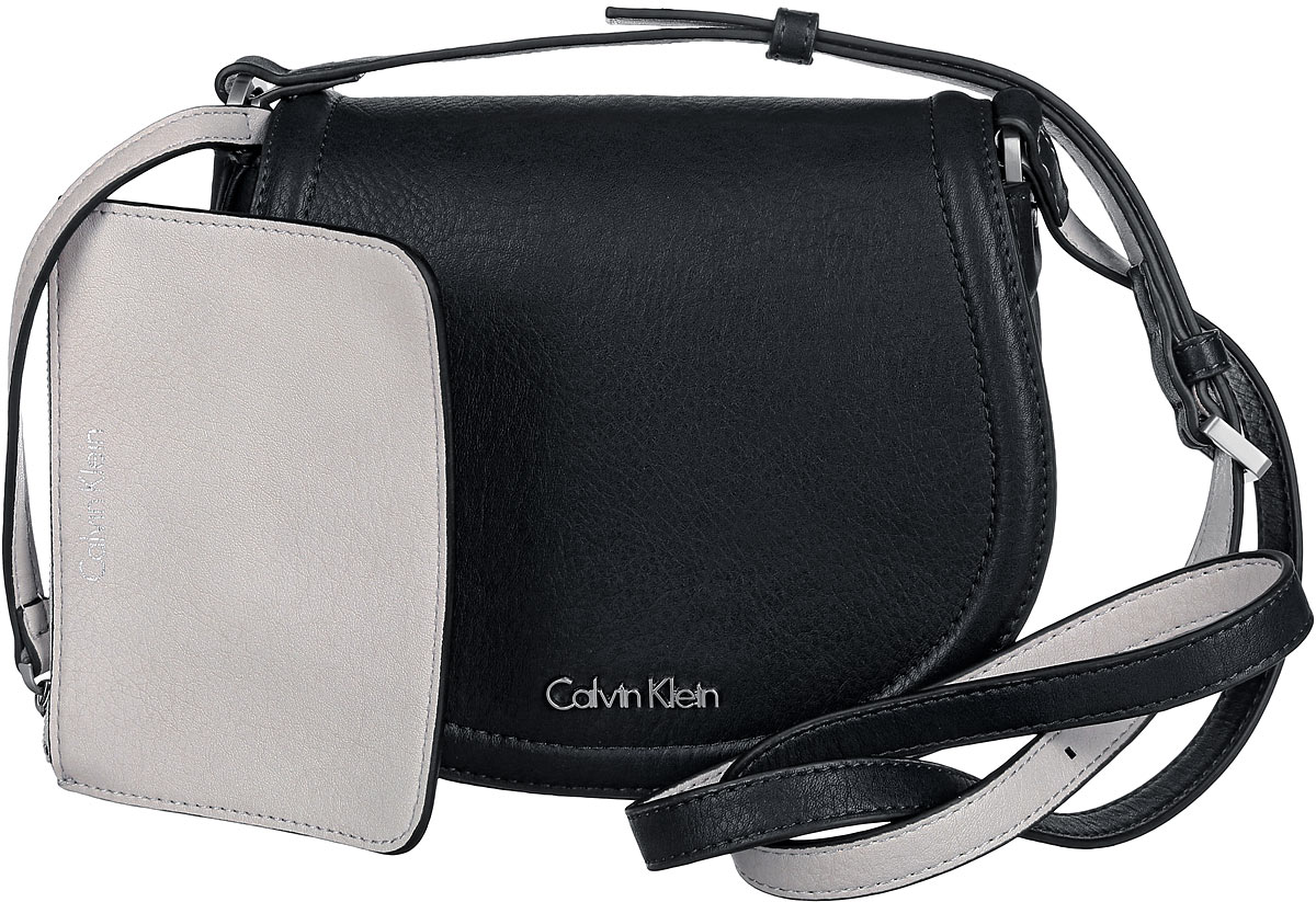 Сумка женская Calvin Klein Jeans, цвет: черный. K60K601646_9100K60K601646_9100 Сумка женская Calvin Klein Jeans, цвет: черный. K60K601646_9100K60K601646_9100Стильная сумка Calvin Klein выполнена из искусственной кожи с зернистой фактурой, оформлена металлической фурнитурой с логотипом бренда. Изделие содержит одно отделение, которое закрывается клапаном на магнитную кнопку. Внутри сумки размещены накладной кармашек для мелочей и врезной карман на застежке-молнии. Сумка оснащена практичным плечевым ремнем регулируемой длины. В комплекте с изделием поставляется небольшой кошелек на застежке-молнии, который фиксируется к сумке при помощи карабина, и чехол для хранения. Модная сумка идеально подчеркнет ваш неповторимый стиль.