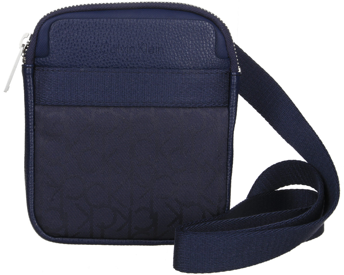 Сумка мужская Calvin Klein Jeans, цвет: темно-синий. K50K502138_000K50K502138_000 Сумка мужская Calvin Klein Jeans, цвет: темно-синий. K50K502138_000K50K502138_000Стильная сумка Calvin Klein Jeans выполнена из поливинилхлорида с добавлением хлопка и полиэстера, оформлена символикой бренда. Изделие содержит одно отделение, которое закрывается на застежку-молнию. Внутри сумки размещен один накладной кармашек для мелочей и один прорезной на застежке-молнии. Спереди расположен один открытый накладной карман. Сумка оснащена плечевым ремнем регулируемой длины. В комплекте с изделием поставляется чехол для хранения.