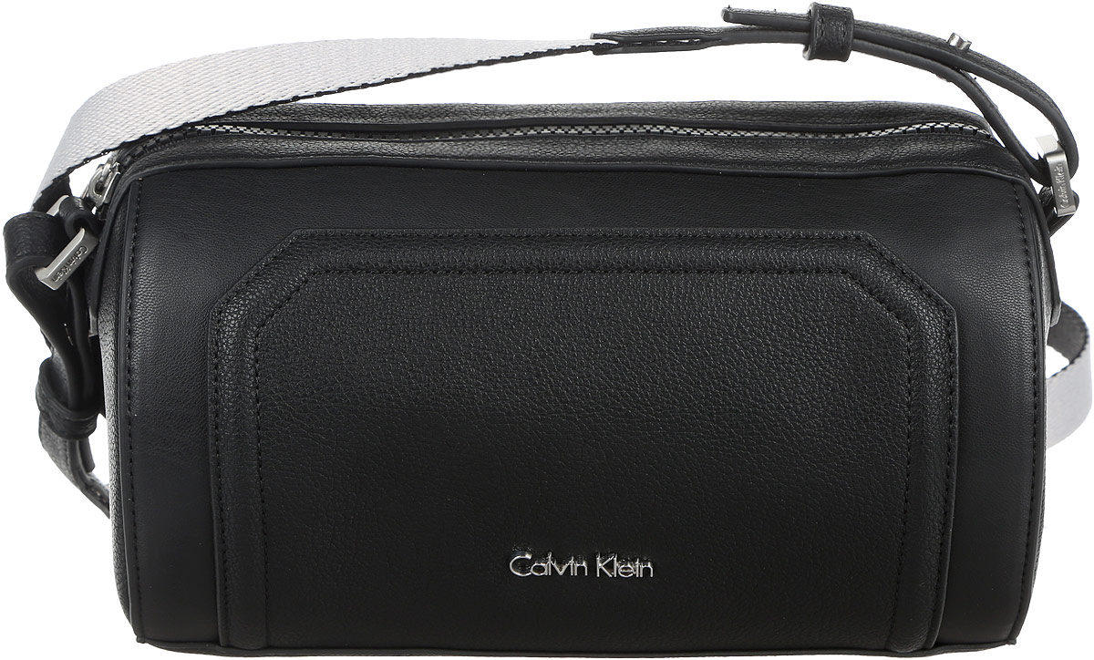 Сумка женская Calvin Klein Jeans, цвет: черный. K60K602410_9100K60K602410_9100 Сумка женская Calvin Klein Jeans, цвет: черный. K60K602410_9100K60K602410_9100Стильная женская сумка Calvin Klein Jeans выполнена из полиуретана. Изделие имеет одно отделение, закрывающееся на застежку-молнию. Внутри сумки находится накладной открытый карман. Сумка оснащена текстильным регулируемым наплечным ремнем.
