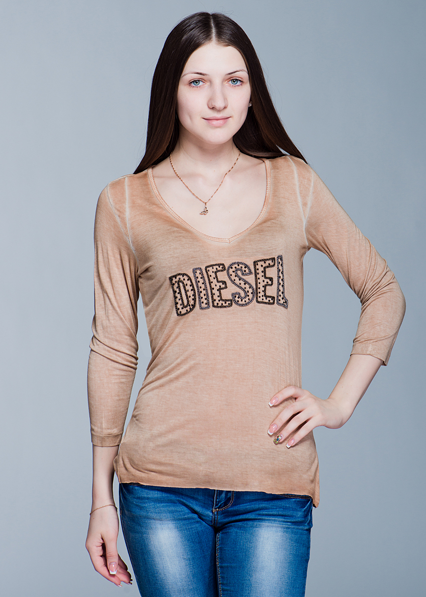 ФутболкаI300S4LL.00QXX ФутболкаI300S4LL.00QXXСтильный женский лонгслив Diesel слегка расклешенного к низу кроя выполнен из высококачественного материала. Модель с V-образным вырезом горловины и рукавами ?, расшит на груди бисером в виде логотипа бренда. Низ лонгслива не обработан. Вискоза является волокном, произведенным из натурального материала - целлюлозы (древесины). Иногда ее называют древесный шелк. Эта ткань на ощупь мягкая и приятная, образует красивые складки. Материал очень хорошо впитывает влагу, не образует катышек со временем, не выцветает на солнце и обладает приятным шелковистым блеском. В таком лонгсливе вы будете выглядеть изящно и грациозно.