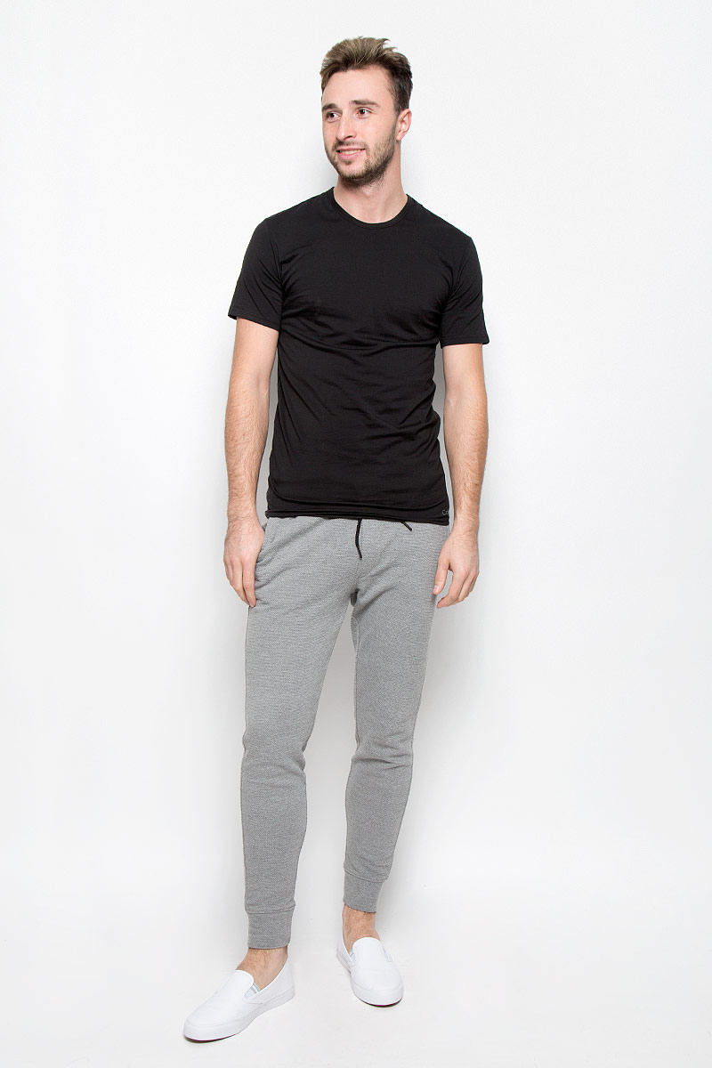 ФутболкаNB1213A ФутболкаNB1213AСтильная мужская футболка Calvin Klein Underwear, выполненная из натурального хлопка с добавлением эластана, необычайно мягкая и приятная на ощупь, не сковывает движения и позволяет коже дышать, обеспечивая комфорт. Модель с V-образным вырезом горловины и короткими рукавами внизу оформлена надписью Calvin Klein. Вырез горловины дополнен эластичной трикотажной резинкой, что предотвращает деформацию при носке. Футболка Calvin Klein Jeans станет отличным дополнением к вашему гардеробу.