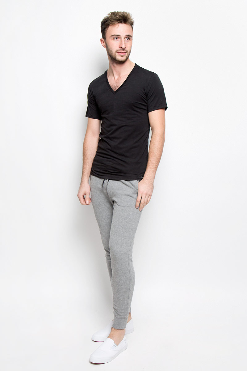ФутболкаNB1217A ФутболкаNB1217AСтильная мужская футболка Calvin Klein Underwear, выполненная из натурального хлопка с добавлением эластана, необычайно мягкая и приятная на ощупь, не сковывает движения и позволяет коже дышать, обеспечивая комфорт. Модель с V-образным вырезом горловины и короткими рукавами внизу оформлена надписью Calvin Klein. Вырез горловины дополнен эластичной трикотажной резинкой, что предотвращает деформацию при носке. Футболка Calvin Klein Jeans станет отличным дополнением к вашему гардеробу.