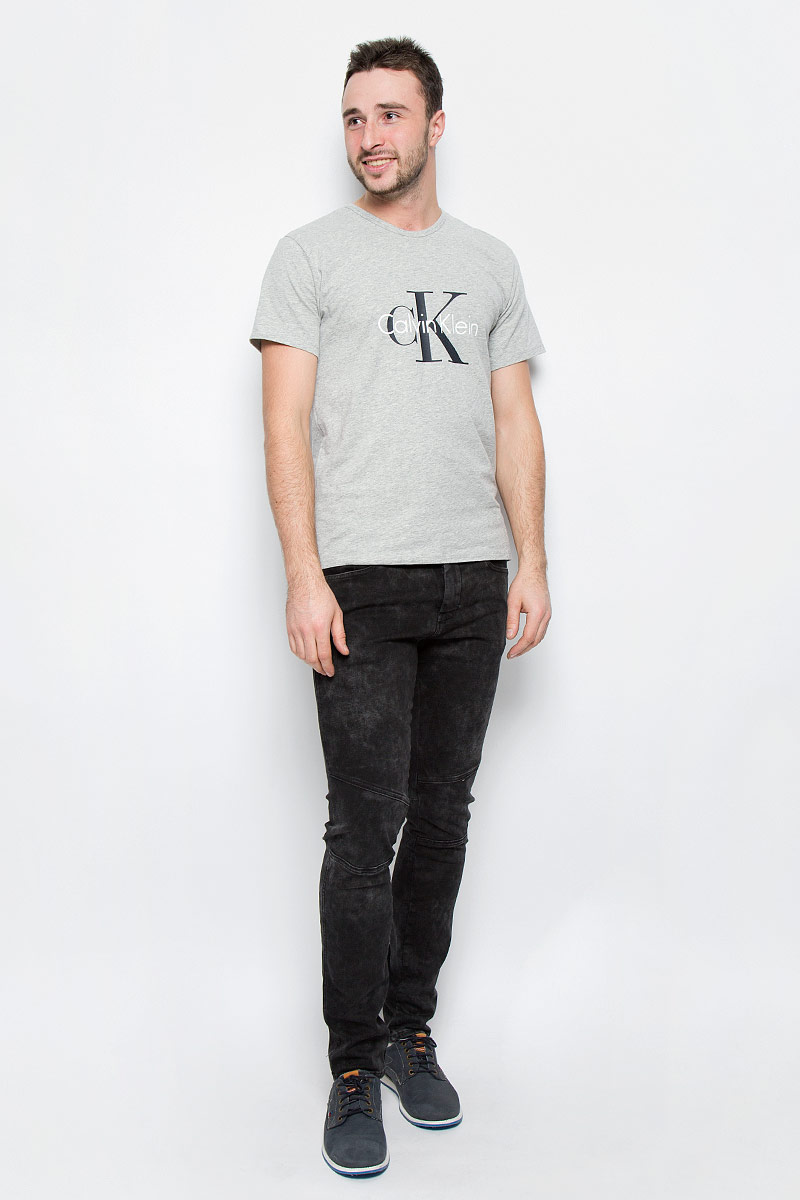 ФутболкаNM1328A_001 ФутболкаNM1328A_001Мужская футболка Calvin Klein Underwear выполнена из эластичного хлопка. Модель с круглым вырезом горловины и короткими рукавами оформлена брендовым логотипом. Горловина дополнена трикотажной резинкой.