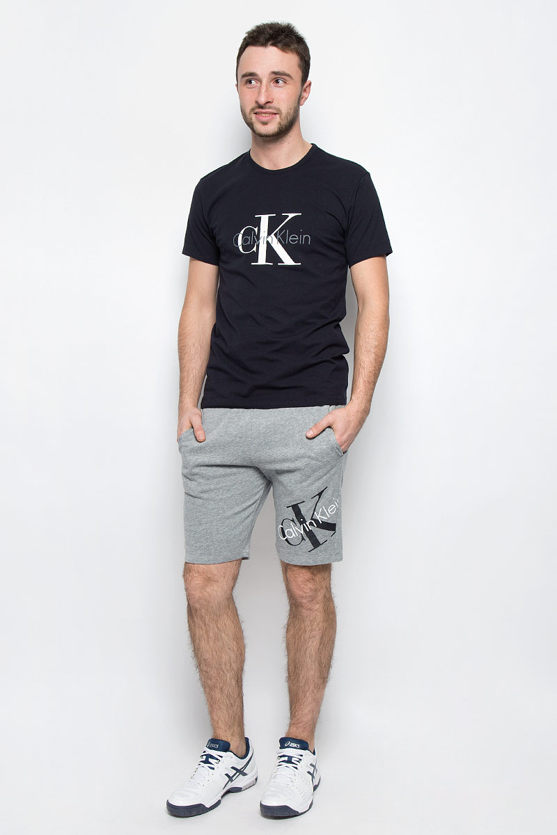ШортыNM1269E_2GY ШортыNM1269E_2GYМужские шорты Calvin Klein Underwear выполнены из хлопка с добавлением полиэстера. Модель по поясу дополнена эластичной резинкой и шнурком-кулиской для лучшей посадки изделия по фигуре. В боковых швах обработаны втачные карманы. Шорты оформлены термоаппликацией в виде названия бренда.