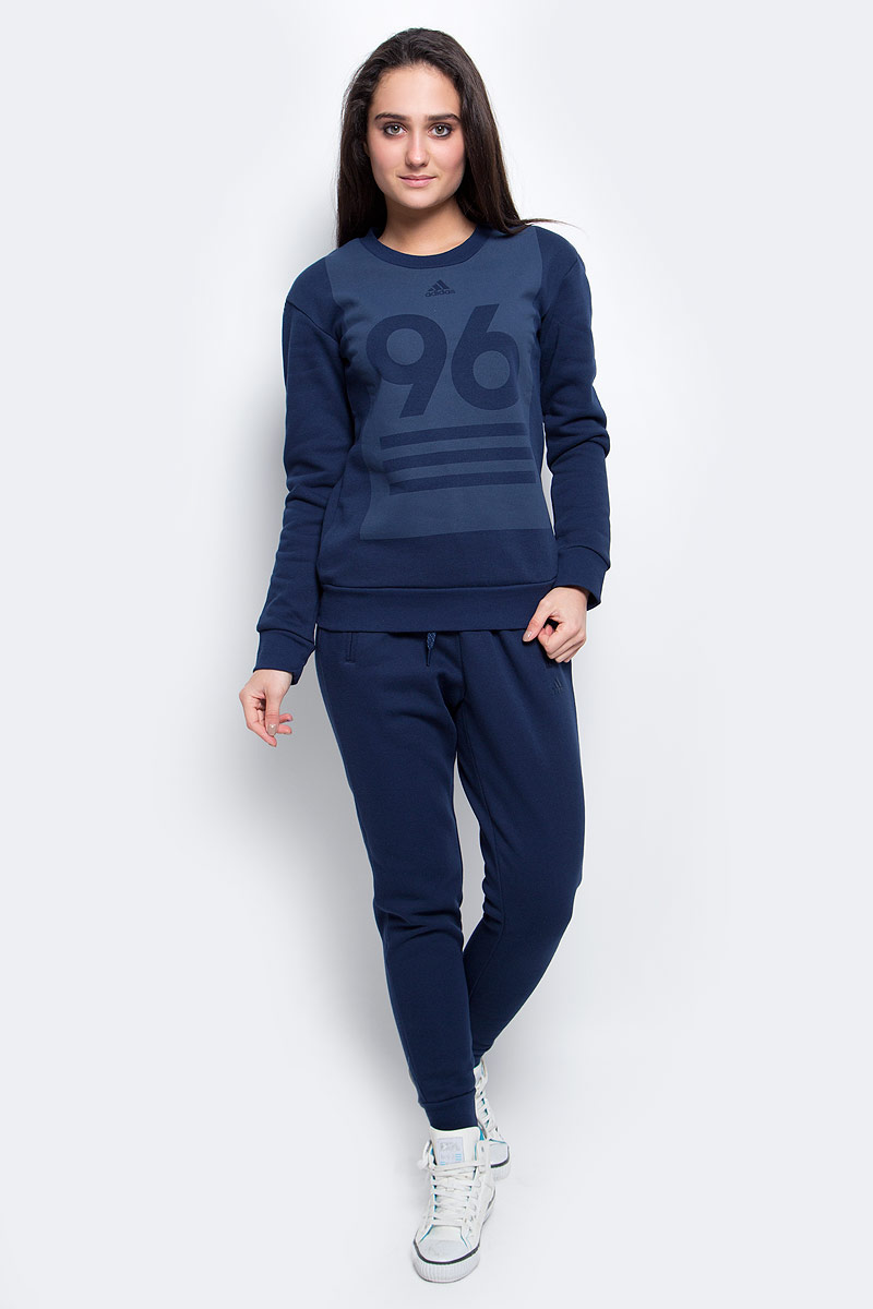 Спортивный костюмAY1798 Спортивный костюмAY1798Спортивный женский костюм Adidas Crew Neck TS выполнен из мягкого флиса. Джемпер украшен крупным числом 96 - годом, когда впервые появился фирменный логотип adidas Sport Perfomance. Рифленые манжеты, ворот и нижний край. Современный крой с зауженными брючинами и заниженным шаговым швом. Боковые карманы, эластичный пояс на регулируемых завязках-шнурках.