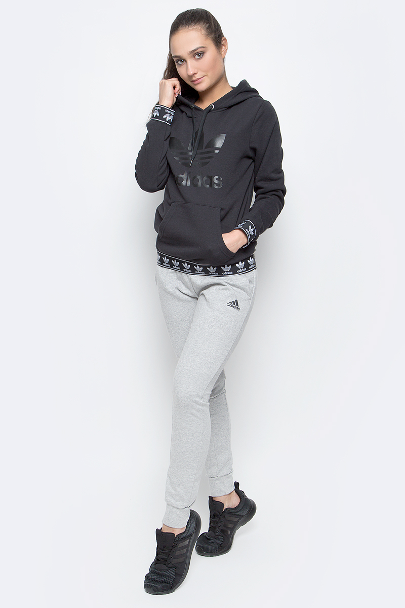 ТолстовкаBJ8307 ТолстовкаBJ8307Женская толстовка adidas Logo с длинными рукавами и капюшоном изготовлена из хлопка с добавлением полиэстера. Рукава и низ толстовки дополнены широкими эластичными манжетами с логотипом бренда. Объем капюшона регулируется при помощи шнурка-кулиски. Спереди расположен накладной карман-кенгуру. Толстовка украшена крупным принтом с изображением логотипа adidas на груди.