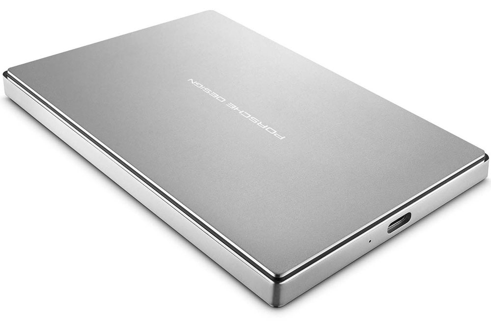 LaCie Porsche Design Mobile Drive 1TB внешний жесткий диск (STFD1000400)STFD1000400 LaCie Porsche Design Mobile Drive 1TB внешний жесткий диск (STFD1000400)STFD1000400LaCie Porsche Design Mobile Drive - стильный и производительный внешний накопитель, оснащенный новейшим интерфейсом USB 3.1. Данное устройство позволяет хранить, переносить и делиться различными цифровыми файлами в дороге. Благодаря современному интерфейсу скорость передачи данных достигает 5 Гб/сек, что значительно увеличивает скорость копирования и чтения информации. Накопитель выполнен в современном минималистичном дизайне, он имеет компактные размеры (84 х 128 х 10 мм), а вес составляет всего 193 г. Все это позволяет переносить его в кармане или небольшой сумочке. В комплект поставки входит универсальный кабель-переходник для совместимости портов поколений USB 3.0 и 2.0.