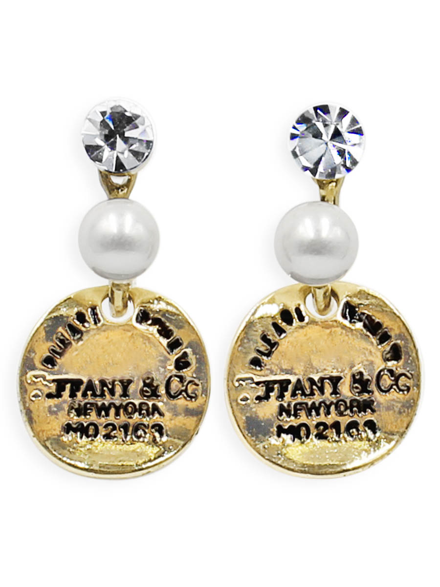 Серьги Taya, цвет: золотистый. T-B-12360T-B-12360-EARR-GOLD Серьги Taya, цвет: золотистый. T-B-12360T-B-12360-EARR-GOLDСерьги-гвоздики с заглушкой металл-пластик изготовлены из бижутерного сплава. С одной стороны скобы кристалл, с другой оформлена мелкая жемчужина. Снизу подвижно крепится монетка с надписями.