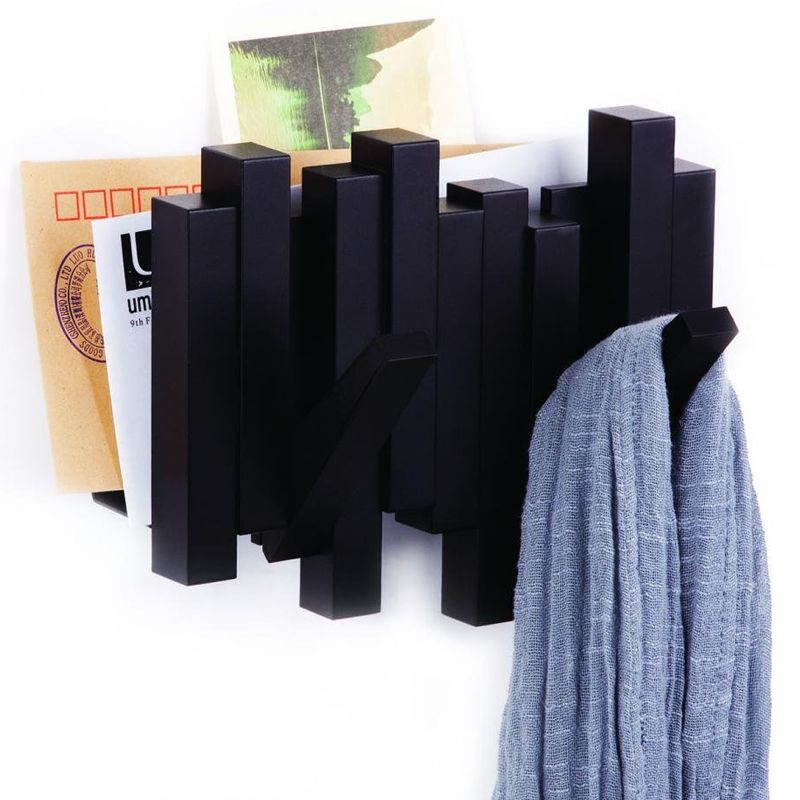 Газетница-вешалка Umbra Sticks, цвет: черный, 2 крючка318209-040 Газетница-вешалка Umbra Sticks, цвет: черный, 2 крючка318209-040Интересная газетница-вешалка Umbra Sticks непременно дополнит ваш интерьер. На первый взгляд, это просто газетница, но если присмотреться, то можно заметить два крючка - они откидываются, если надо что-то повесить, и прячутся внутрь конструкции, когда не нужны. Это экономит место, выглядит элегантно, а главное, идеально подходит для небольших помещений. Каждый крючок может выдержать до 2,3 кг. Вешалка из прочного пластика подойдет для сумок, шарфов, головных уборов и верхней одежды. Размер вешалки: 20 см х 17 см х 5,5 см.