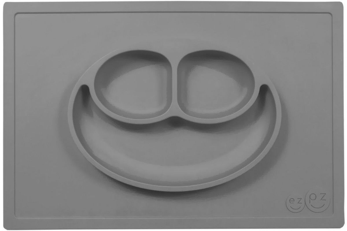 Ezpz Тарелка детская Happy Mat цвет серый115510 Ezpz Тарелка детская Happy Mat цвет серый115510Ezpz Happy Mat - необычная силиконовая тарелка-плейсмат, которая не имеет аналогов. Ее главная особенность заключается в том, что тарелку невозможно перевернуть или опрокинуть. С ней ребенок не сможет испачкать стол или, что гораздо важнее, обжечься горячей пищей.Изготовлена из силикона высочайшего качества и абсолютно безопасна. Не имеет липучек или присосок - фиксация происходит на любой ровной горизонтальной поверхности за счет плоской, гладкой поверхности тарелочки - мата. Подходит для использования в микроволновке и посудомоечной машине. Выглядит как улыбающаяся рожица, что очень нравится детям и их мамам.Тарелка разработана и запатентована в США. Идея создания удобной, безопасной посуды для детей, принадлежит многодетной маме, которая как никто другой знает, как сложно уследить за детками во время еды и сохранить при этом чистоту и порядок. Благодаря такой тарелочке прием пищи становится веселым и безопасным, а кухня остается чистой и опрятной.Объем 540 мл.