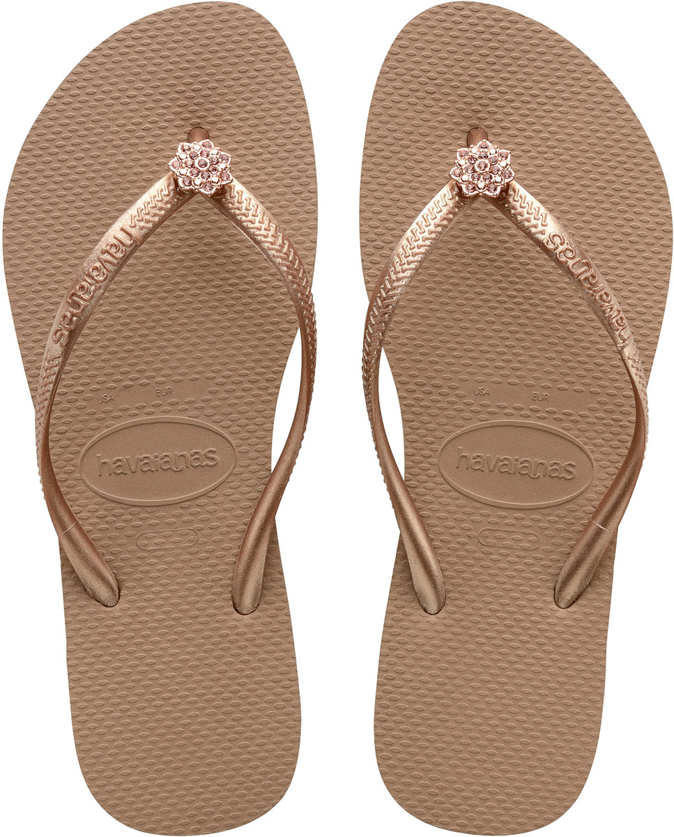 Сланцы женские Havaianas Slim Crystal Poem, цвет: темно-бежевый. 41274068548. Размер 41/42 (42/43)41274068548 Сланцы женские Havaianas Slim Crystal Poem, цвет: темно-бежевый. 41274068548. Размер 41/42 (42/43)41274068548Модные женские сланцы Slim Crystal Poem от Havaianas придутся вам по душе. Верх модели, выполненный из резины, оформлен рельефным орнаментом, названием бренда и декоративным элементом в виде цветка со стразами. Ремешки с перемычкой гарантируют надежную фиксацию модели на ноге. Подошва выполнена из материала ЭВА. Рифление на верхней поверхности подошвы предотвращает выскальзывание ноги. Рельефное основание подошвы обеспечивает уверенное сцепление с любой поверхностью. Удобные сланцы прекрасно подойдут для похода в бассейн или на пляж.